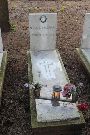 Tombe perpetue dedicate ai caduti per la Libertà, con fiori e una lanterna, in un ambiente tranquillo.