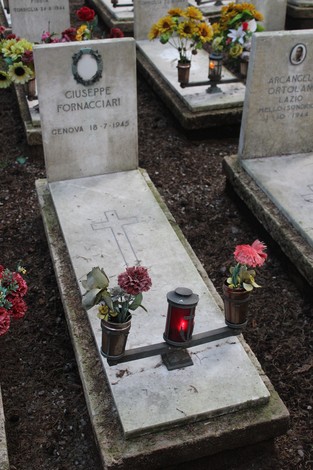 Tombe perpetue con fiori e lumini in memoria dei caduti per la Libertà in un cimitero.