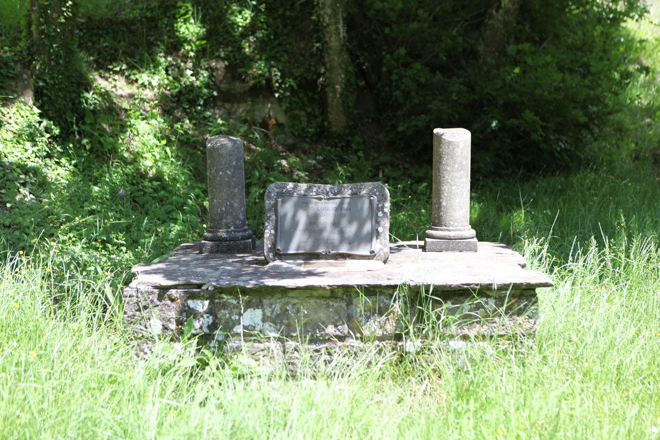 Monumento a Neri e Bellenghi, dedicato a figure storiche, immerso nel verde.