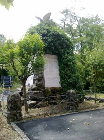 Monumento ai Caduti di Viano, circondato da vegetazione, onora la memoria dei soldati.
