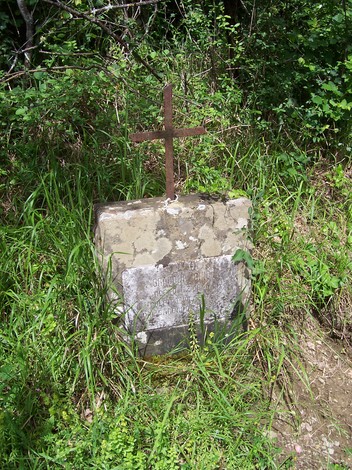 Cippo a Braconi, monumento commemorativo immerso nella natura, con croce in ferro e base in pietra.