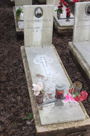 Tombe perpetue dei caduti per la Libertà, decorate con fiori e candele in un cimitero.