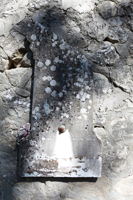 Vecchi sepolcri al cimitero di San Martino, caratterizzati da marmi consumati e licheni sulle superfici.