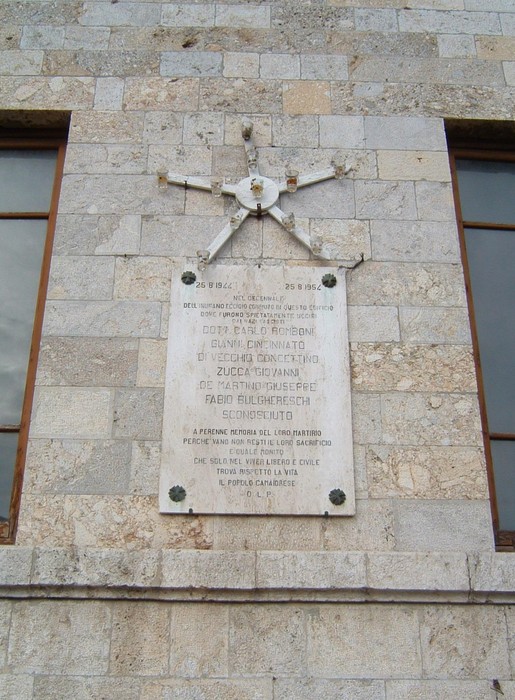 Lapide commemorativa del Palazzo Littorio, con decorazioni simboliche e iscrizioni storiche.