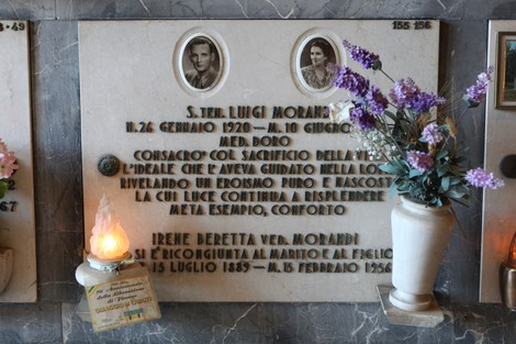 Sepolcro di Luigi Morandi, con foto e memento, decorato con fiori e lumino. Rappresenta un atto di memoria e rispetto.