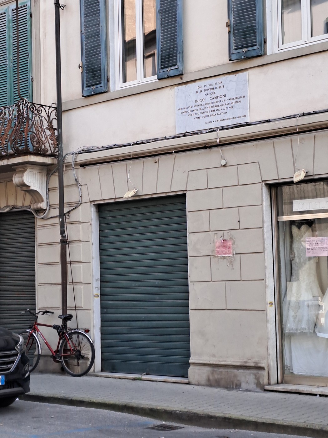 Lapide commemorativa dedicata a Enzo Campioni su una facciata di edificio nel centro città.