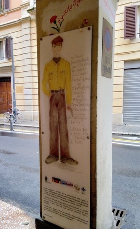 Lapide commemorativa a Bondi con figura illustrativa e dedica, situata lungo una strada urbana.