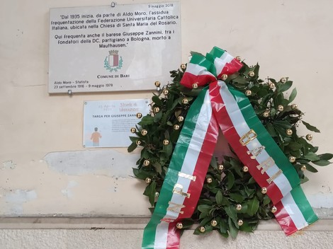 Lapide commemorativa in onore di Giuseppe Zannini, fondatore della DC, a Bologna, con corona d'alloro.