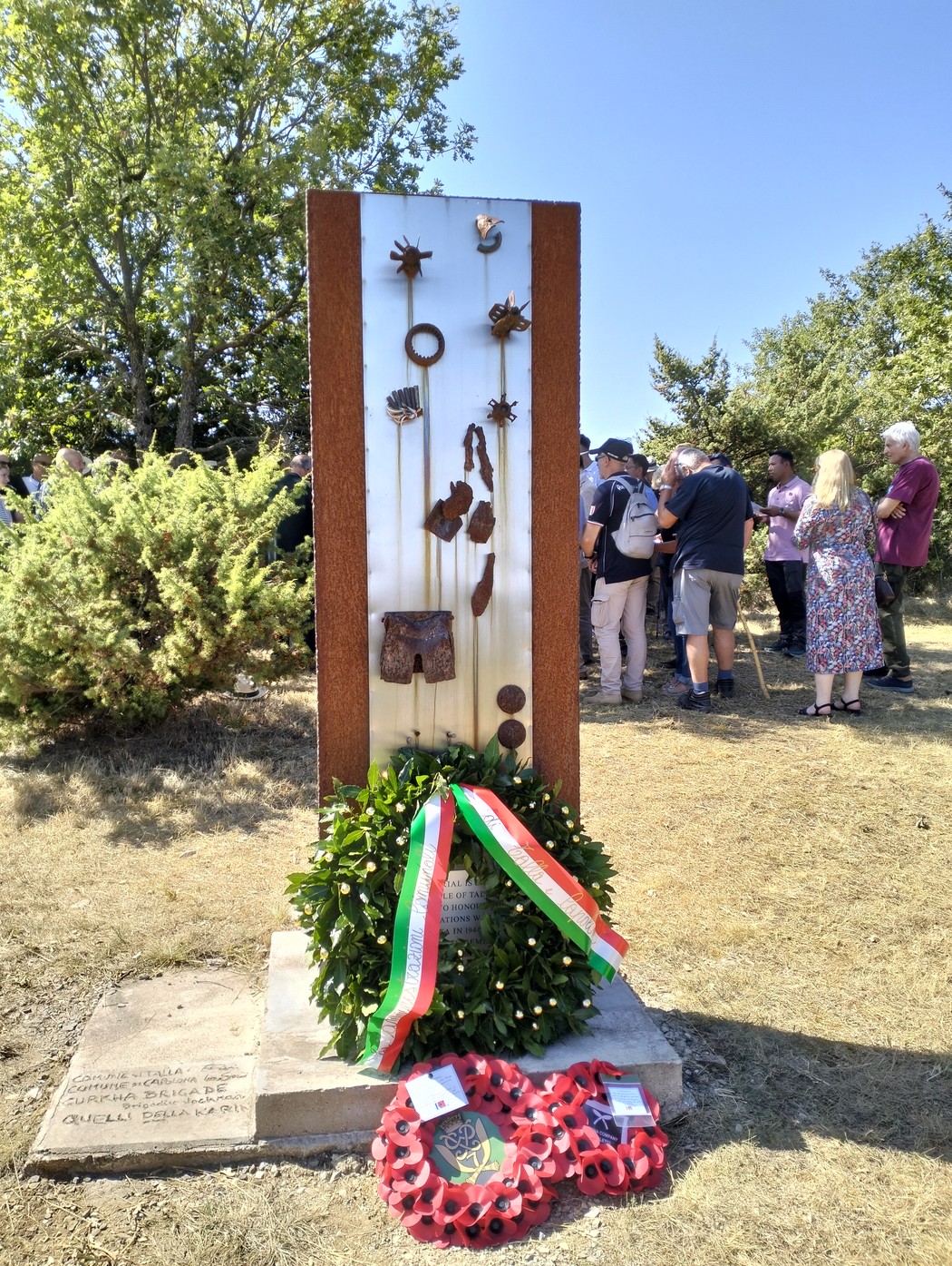 Monumento commemorativo della battaglia di Poggio Grillo, con decorazioni e corone floreali in segno di rispetto.