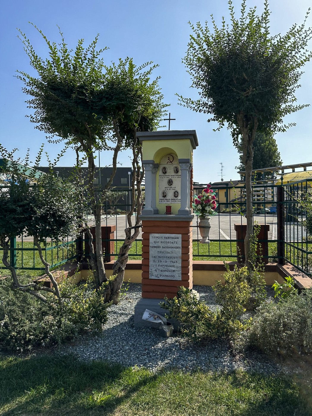 Tabernacolo con decorazioni e piante, situato a Pivetti, in un ambiente curato e tranquillo.