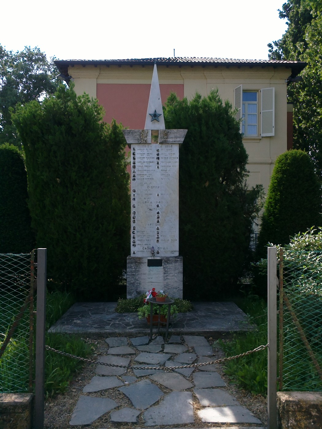 Monumento ai Caduti di Masone, dedicato alla memoria dei soldati, circondato da verde e sentieri in pietra.