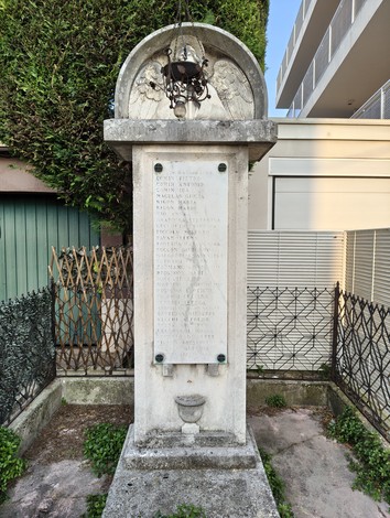 Monumento ai caduti di Santa Bertilla, con iscrizioni commemorative e ornamenti in un contesto urbano.