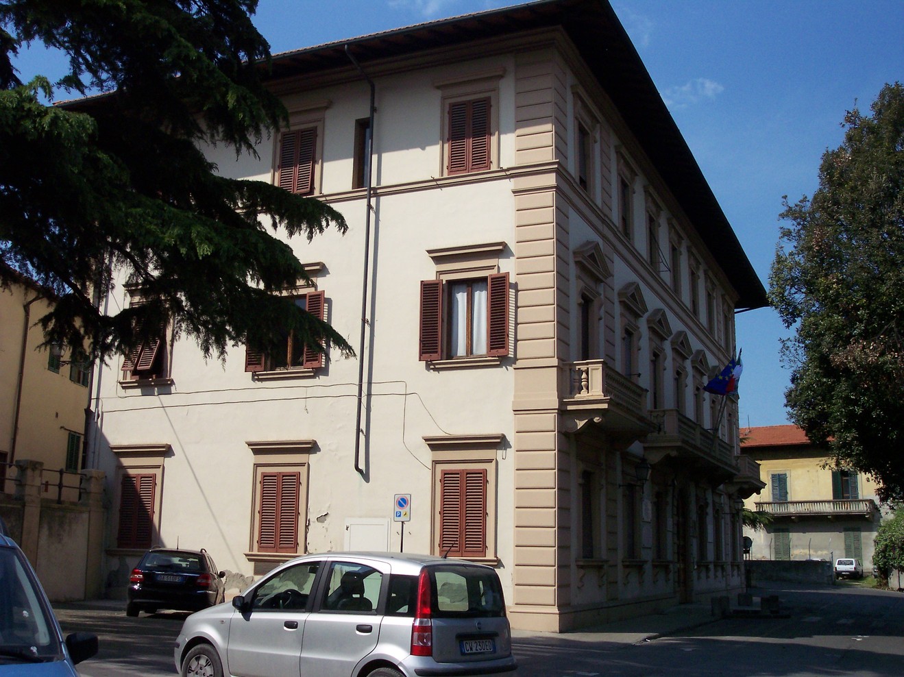Lapide commemorativa situata su un edificio storico, visibile da un angolo della strada.