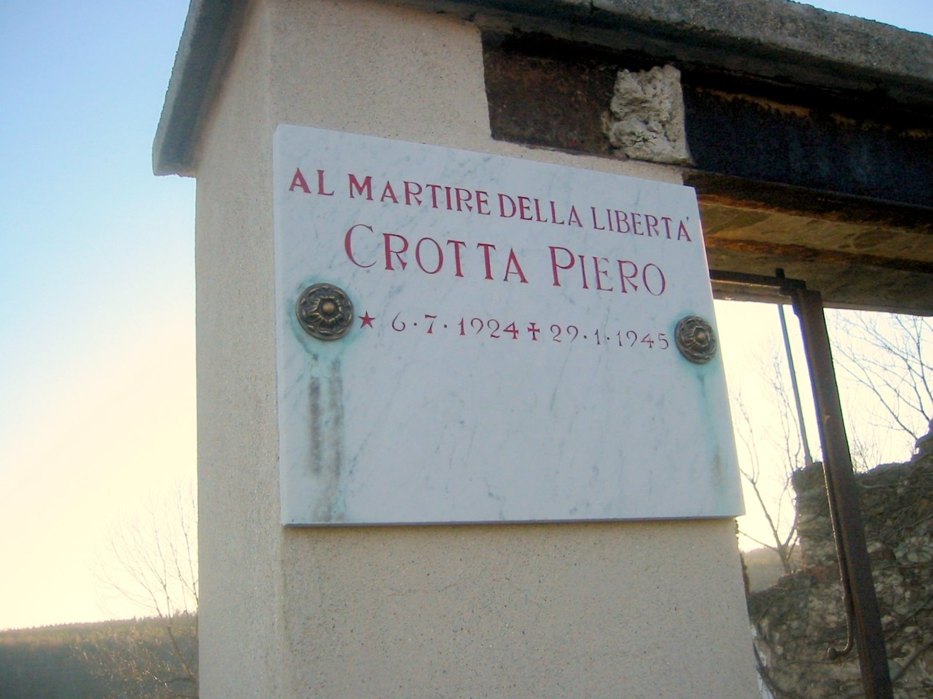 Lapide commemorativa dedicata a Crotta Piero, martire della libertà, situata in un contesto storico.