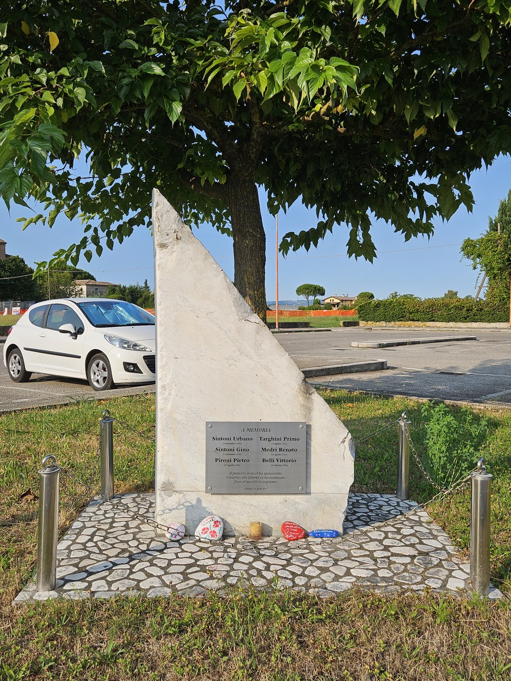 Cippo commemorativo ai Caduti per la Libertà di Gattolino, con decorazioni e ambiente tranquillo.