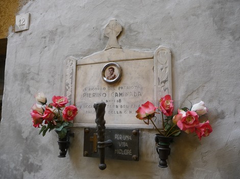 Lapide commemorativa con ornamenti floreali dedicata a Pierino Caminada.