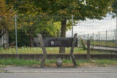 Monumento a Vezzali, dedicato alla libertà, con panchina e vaso, circondato da un paesaggio naturale.