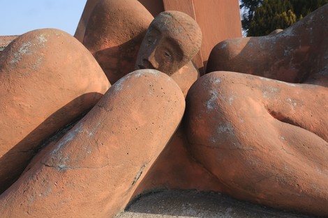 Monumento commemorativo in pietra con figure stilizzate che evocano la sofferenza e il ricordo dell'eccidio di Felisio.