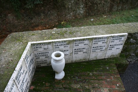 Monumento a Don Raglianti con lapidi in marmo commemorative e urna per omaggi.