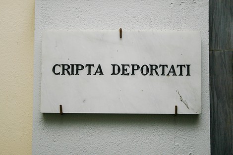 Insegna in marmo con la scritta "Cripta Deportati", un luogo di memoria e commemorazione.