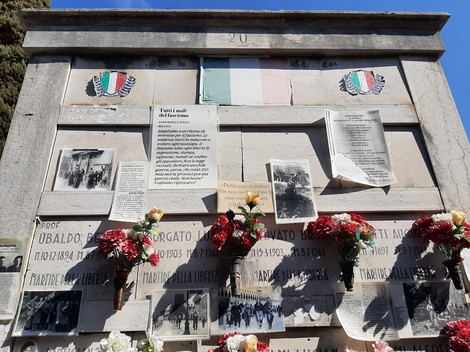 Sacrario ai martiri della libertà, con fotografie storiche e decorazioni floreali in un ambiente commemorativo.
