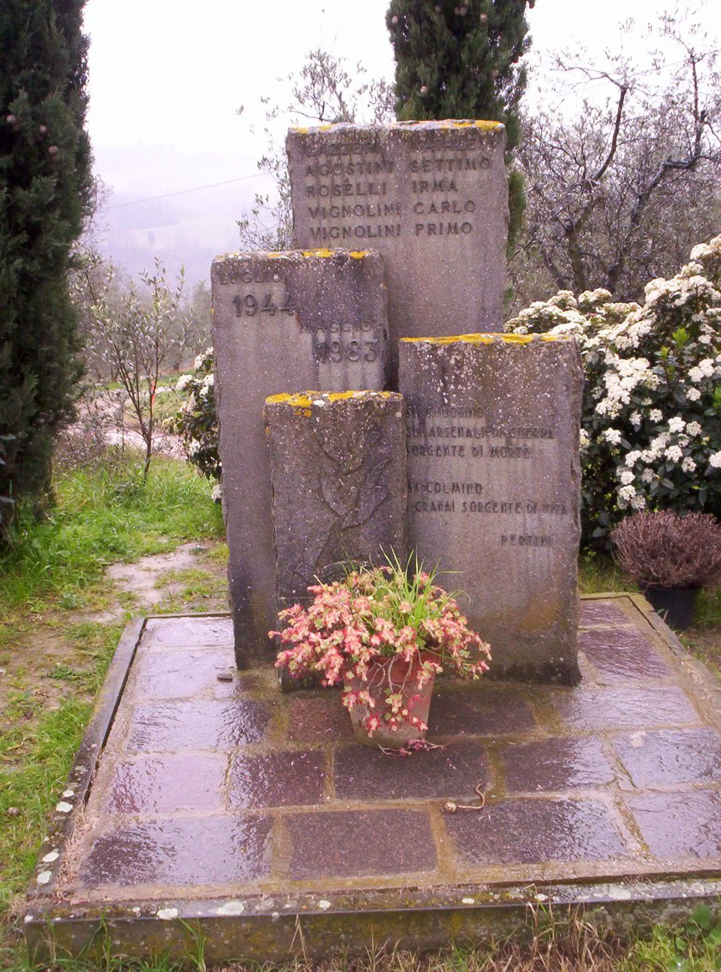Monumento di Montagnana, commemorativo e immerso nella natura, con fiori e arbusti circostanti.