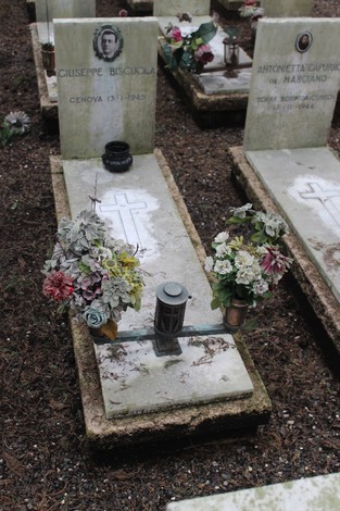 Tombe decorate con fiori e candele in un cimitero, commemorano i caduti per la Libertà.