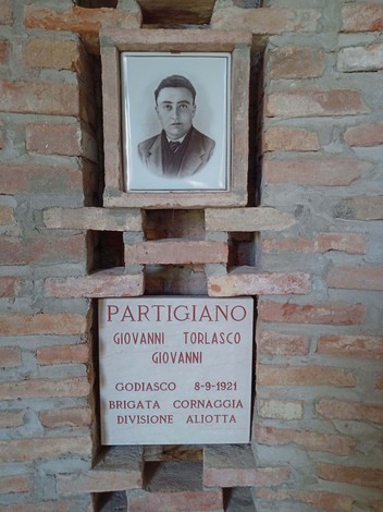 Sacrario dei martiri di Biagasco, con foto e targa commemorativa di un partigiano.