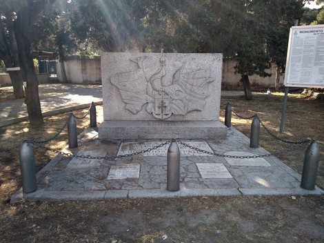 Monumento commemorativo ai caduti dello sbarco alleato, circondato da elementi simbolici e di memoria storica.