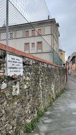Lapide commemorativa dedicata a Gastardelli, situata su un muro in una strada urbana.