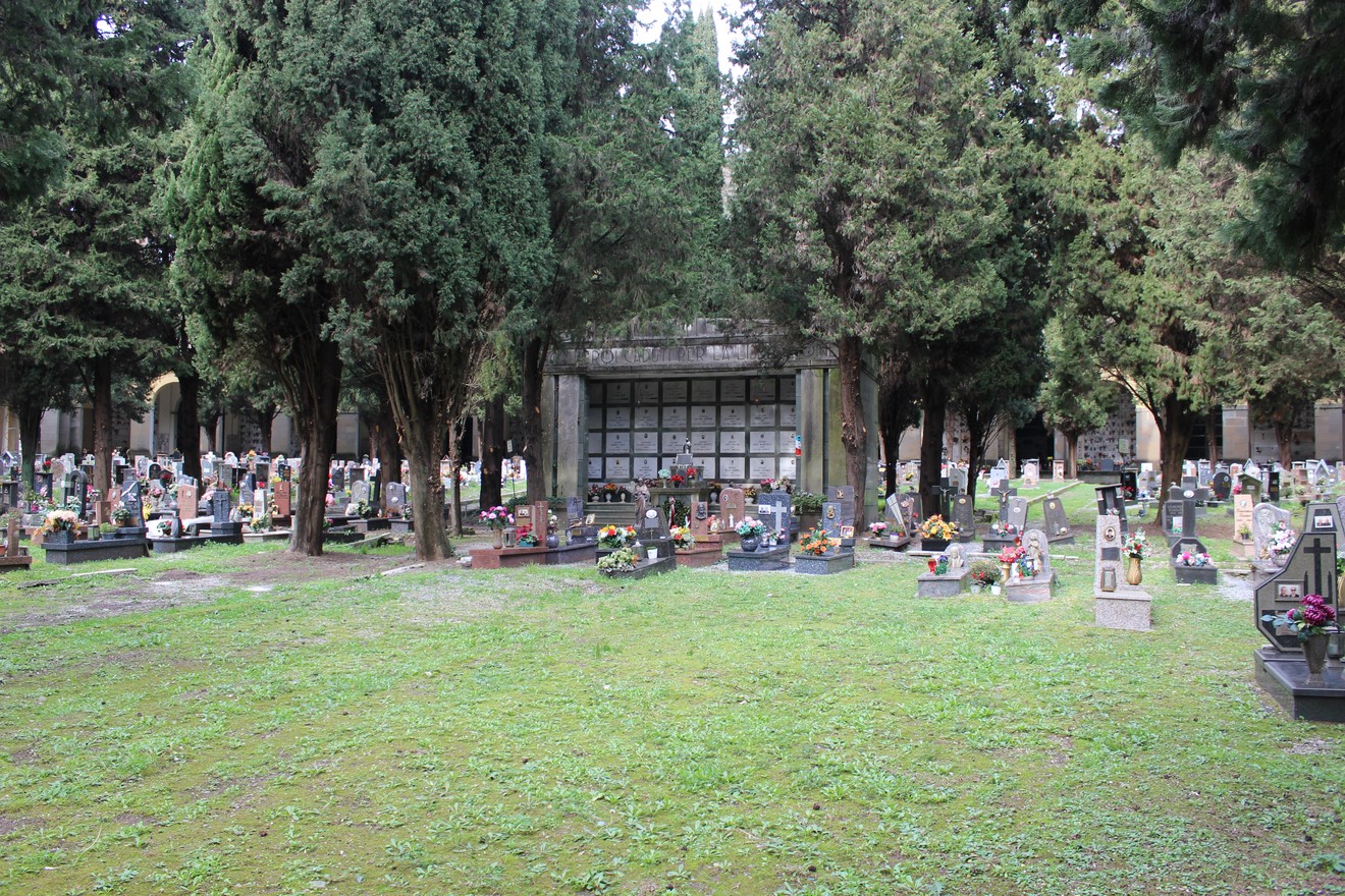 Sacrario dei caduti per la Liberazione, con cimitero e monumento circondati da alberi. Atmosfera di rispetto e commemorazione.