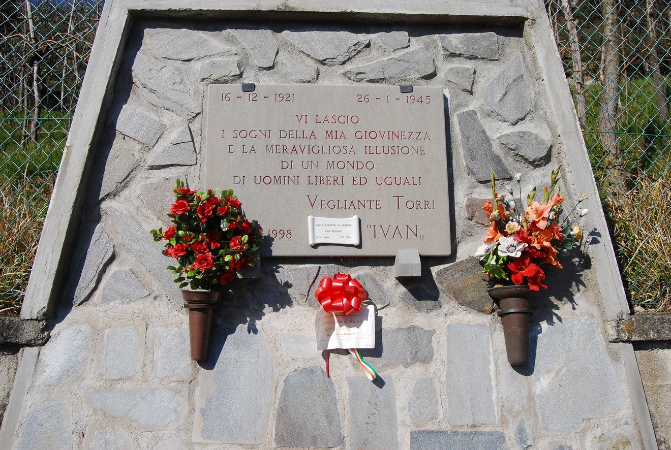 Lapide commemorativa dedicata a Vigilante Torri, con fiori e un nastro, in ricordo della sua vita.