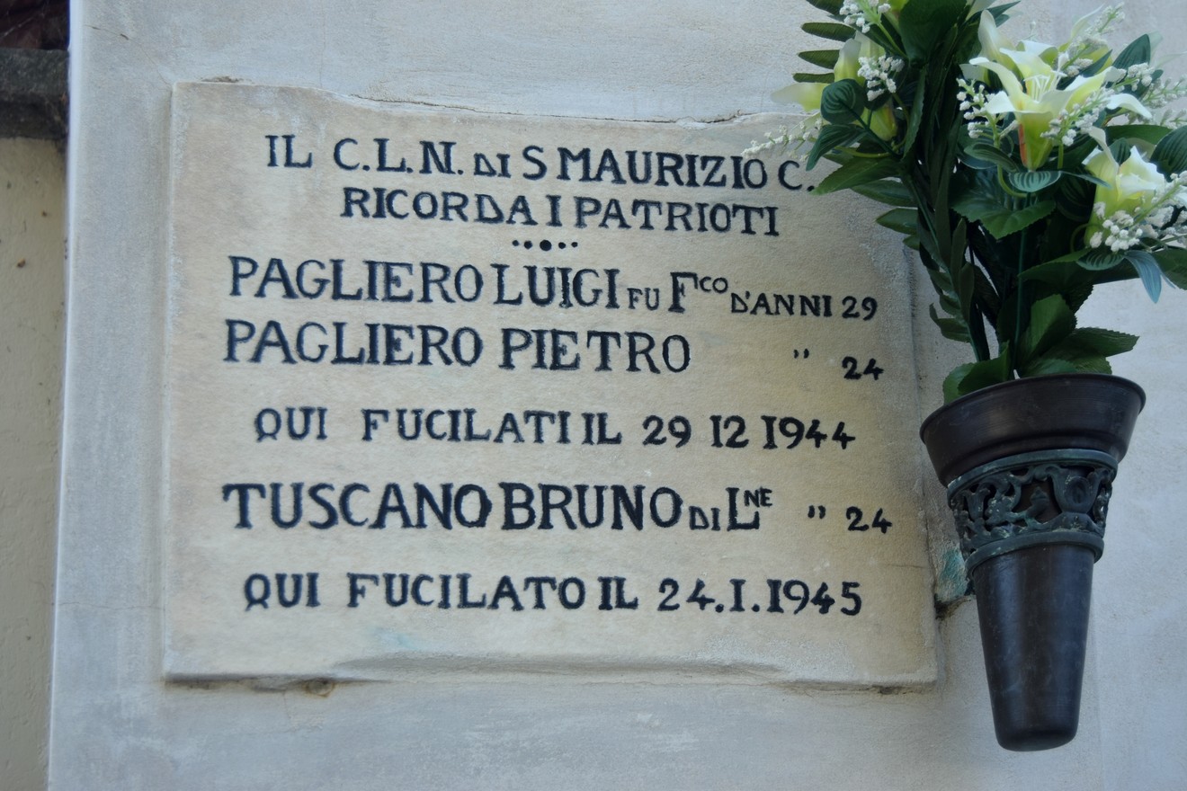 Lapide commemorativa dedicata a Luigi e Pietro Pagliero e Bruno Tuscano, con fiori decorativi.