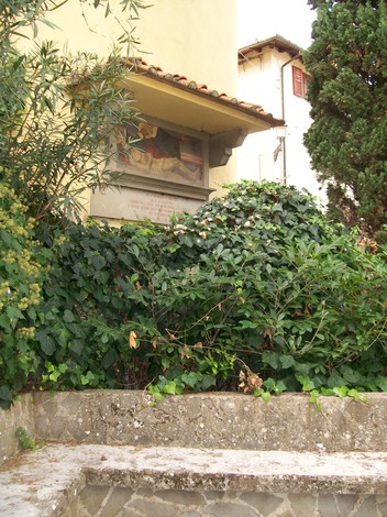 Lapide commemorativa dell'eccidio di Meleto, immersa nel verde, in ricordo delle vittime.