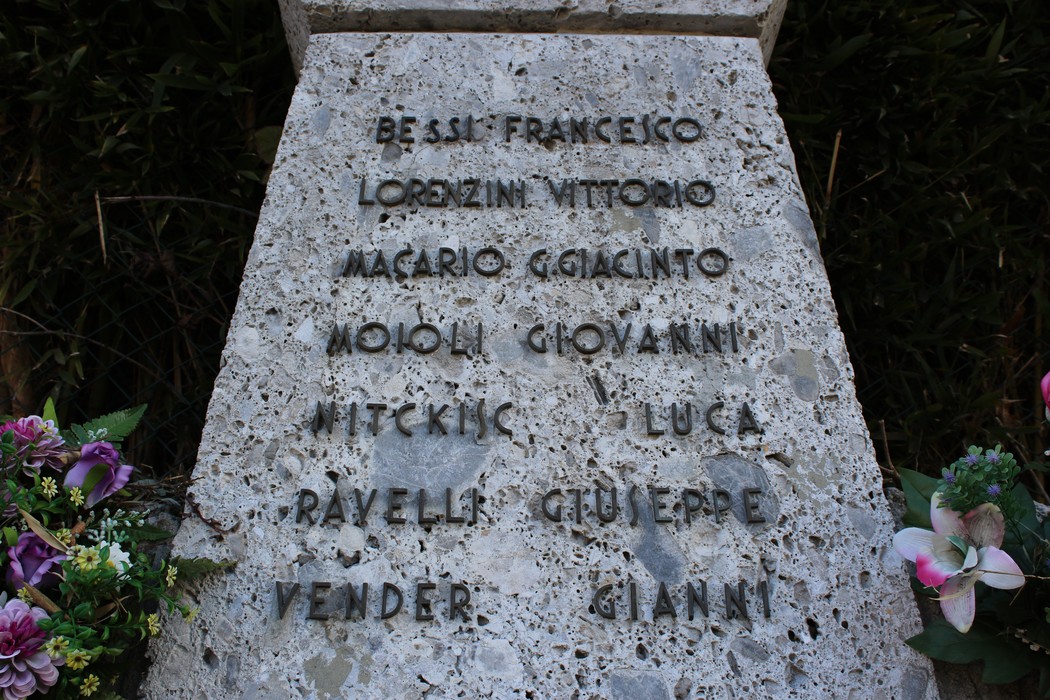 Monumento ai Tredici Martiri, con nome e omaggio ai caduti in granito e fiori decorativi.