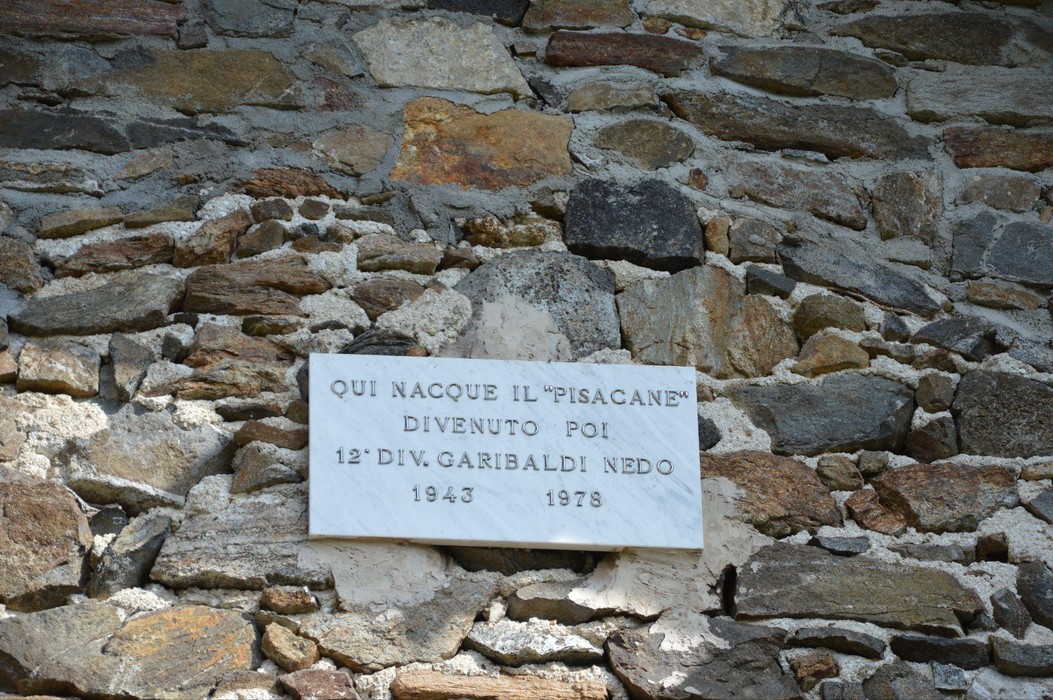 Lapide commemorativa che ricorda la nascita del "Pisacane" e il suo legame con la 12ª Divisione Garibaldi.