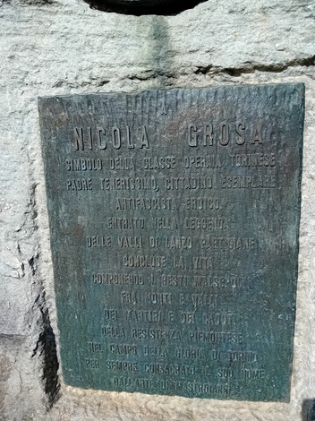 Monumento a Grosa, commemorativo con iscrizioni su una lastra di bronzo su un supporto di pietra.
