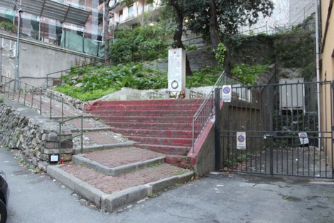 Monumento ai caduti per la Libertà di Staglieno, situato in un'area verde con scalinate e muri in pietra.