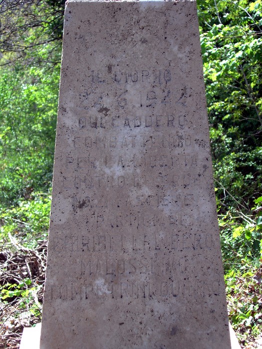 Cippo commemorativo dedicato a Ghiribelli, Malossi e Tompetrini, immerso nella natura.