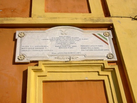 Lapide commemorativa dedicata ai caduti per la Libertà, situata in un contesto storico.
