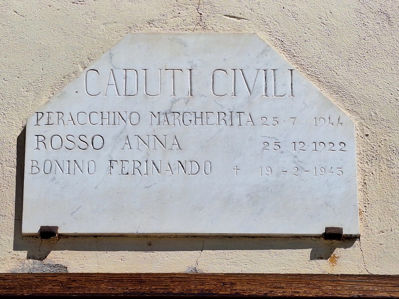 Lapide in marmo su parete, con iscrizione dedicata ai caduti civili e elenco di nomi.