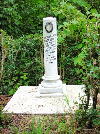 Cippo commemorativo dedicato a Luigi Melzi, situato in un'area verde. Rappresenta la memoria storica locale.