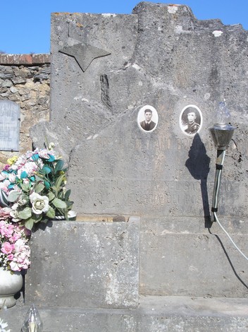 Sepolcro monumentale con decorazioni e doppia fotografia commemorativa.