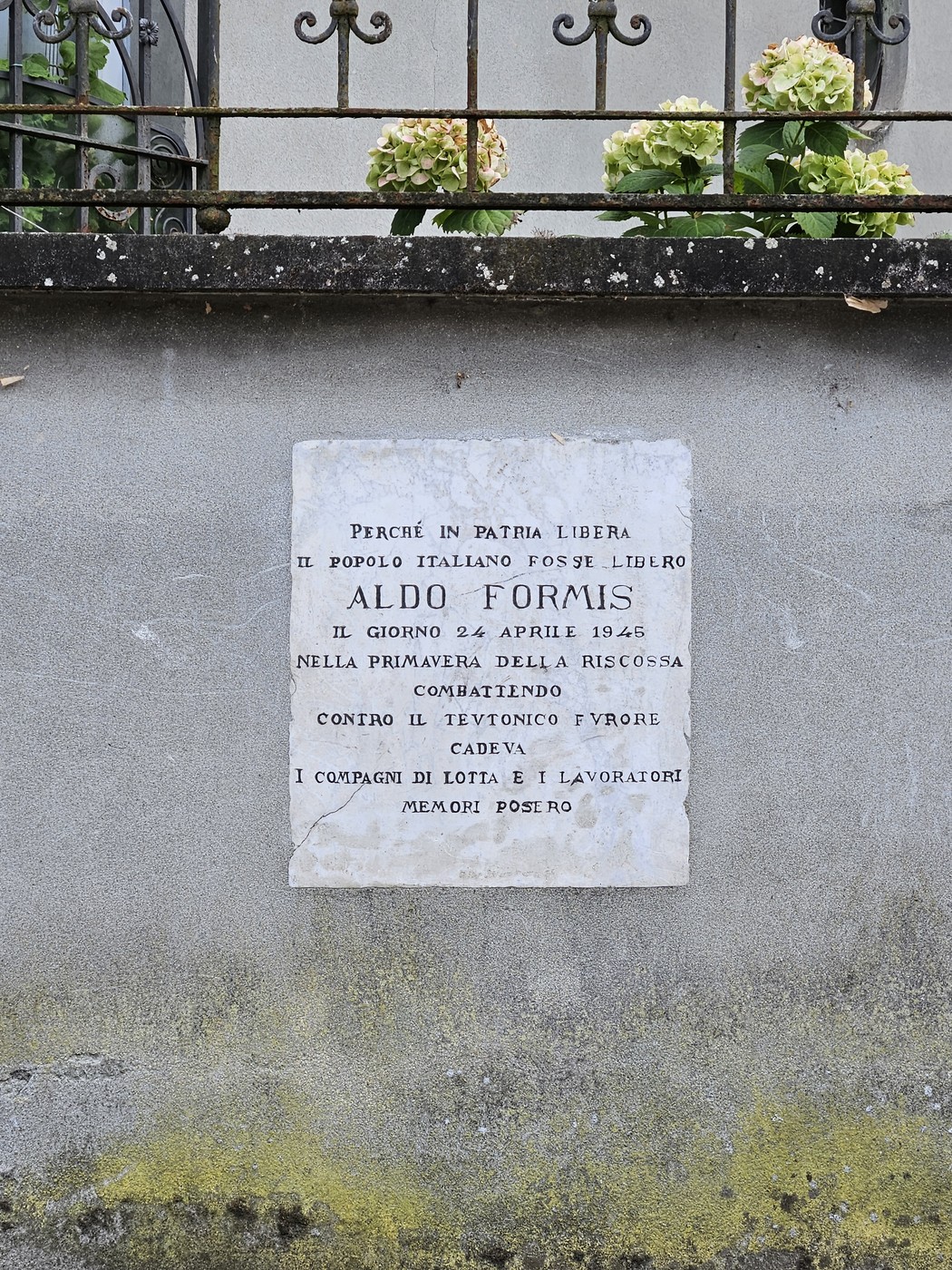 Lapide commemorativa ad Aldo Formis, situata a Formis, con messaggio di ricordo e resistenza.