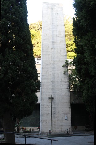 Sacrario dei Partigiani di Sampierdarena, monumento commemorativo con obelisco e croce, circondato da alberi.