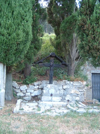Monumento di Castiglione circondato da alberi, con una struttura in pietra e una figura centrale.