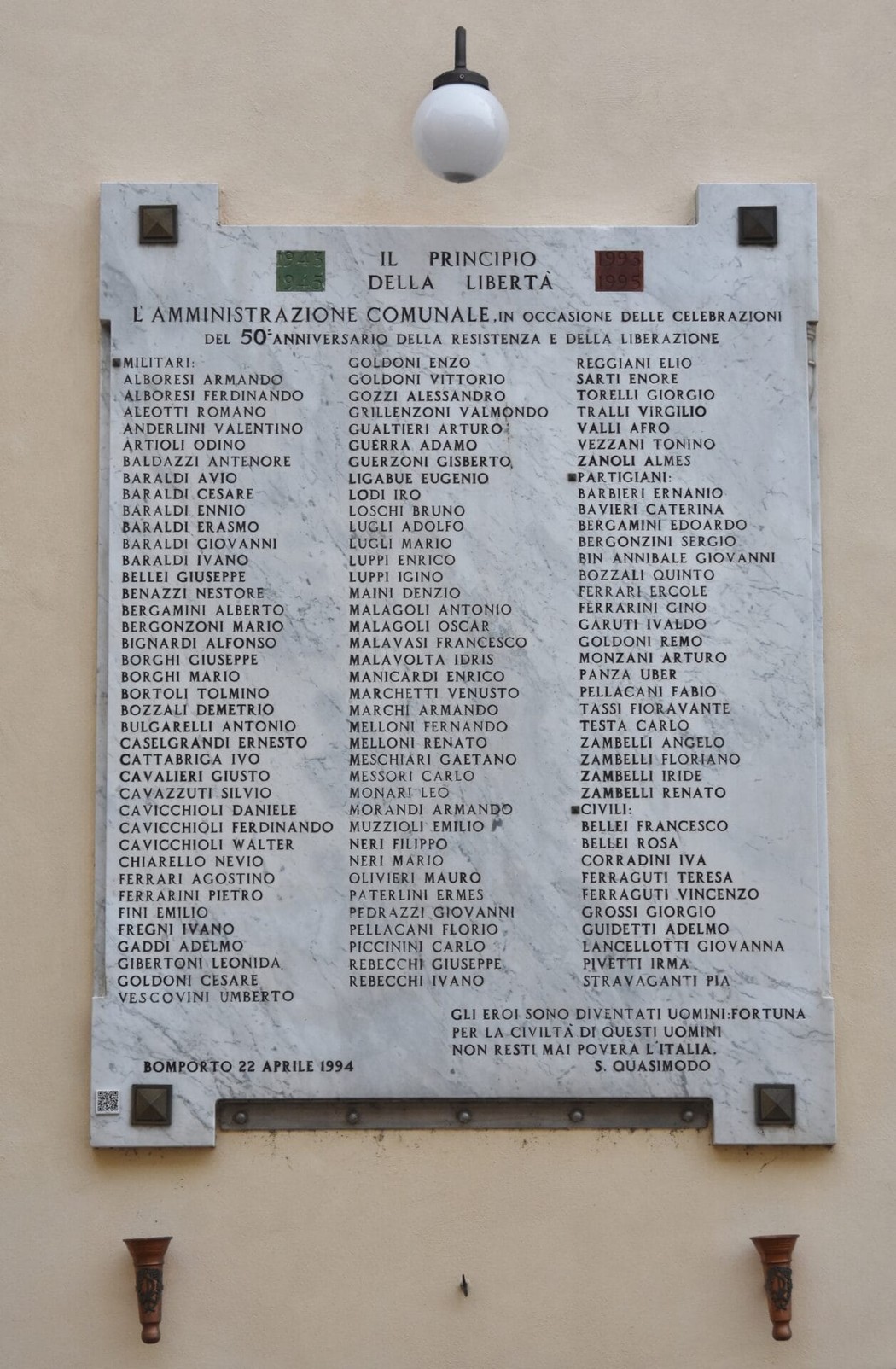 Lapide commemorativa che onora i caduti, con nomi incisi su marmo, situata in un contesto pubblico.