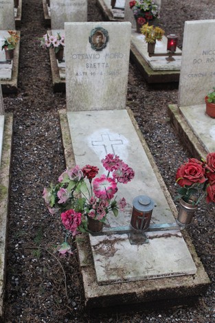 Tombe con fiori e candele, dedicate ai caduti per la Libertà in un cimitero commemorativo.