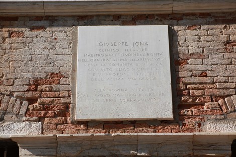 Lapide commemorativa dedicata a Giuseppe Jona, situata su una facciata di mattoni.