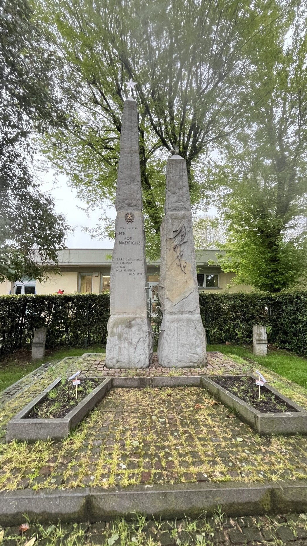 Monumento ai caduti della Resistenza, con monumenti in pietra e decorazioni, immerso nel verde di un parco.